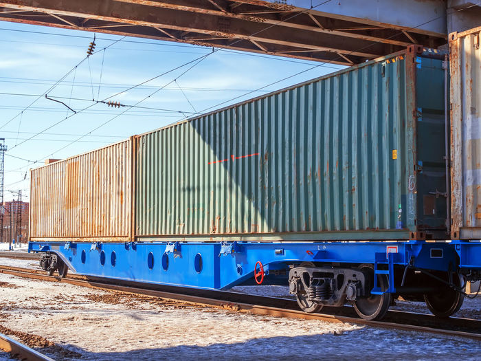 Long freight train of idler flat cars loaded with intermodal 40ft containers on the marshalling yard