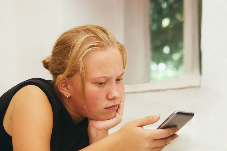 Low angle view of teenage girl using mobile phone