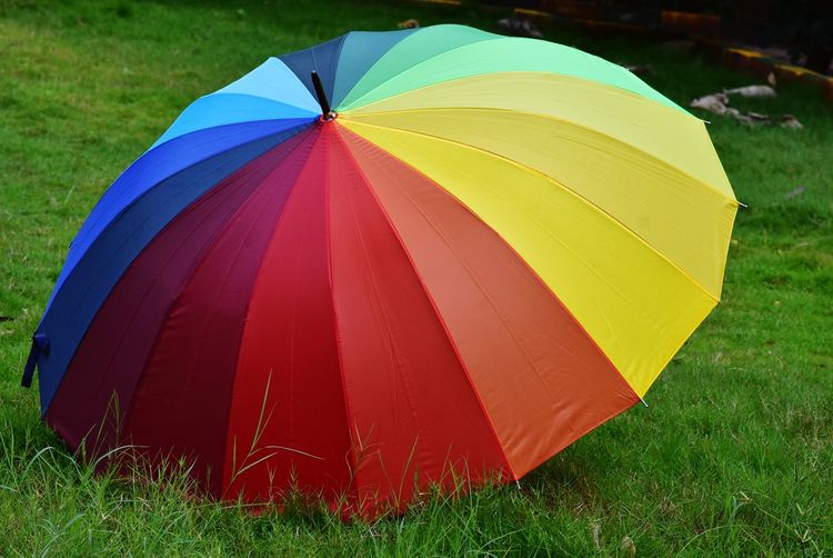 Close-up of multi colored umbrella on field