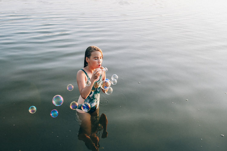 High angle view of woman with bubbles in lake