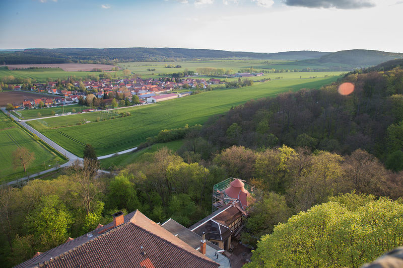 High angle view of agricultural field and houses against sky