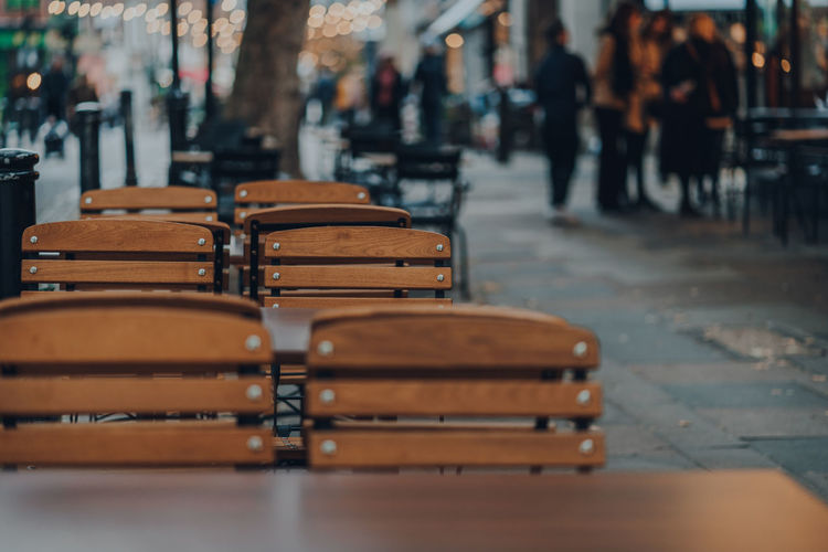 Close-up of empty chairs on table in city