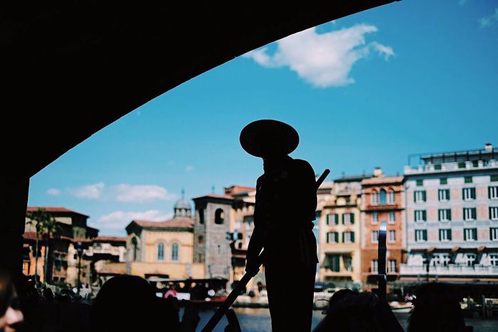 Silhouette gondolier in boat against city