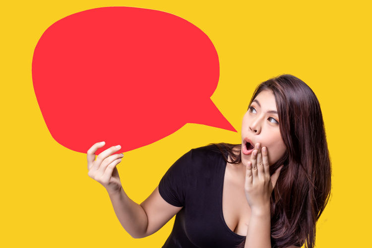 Portrait of a young woman against yellow background
