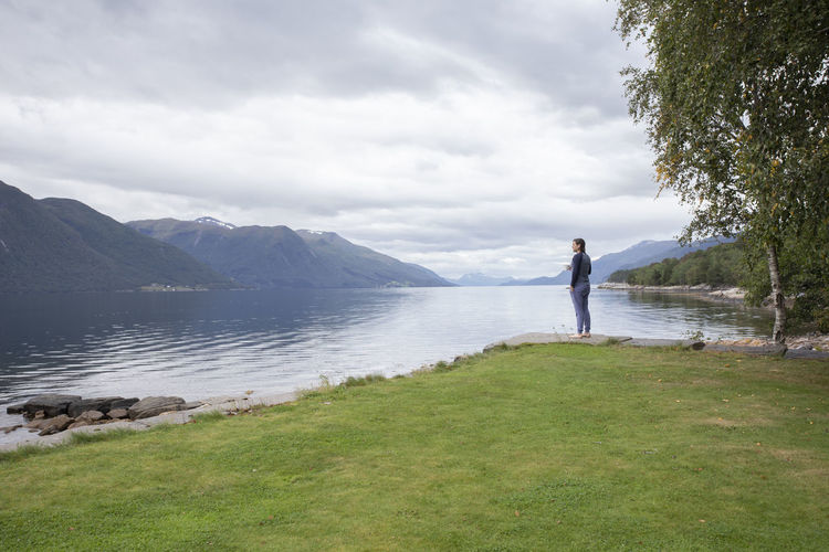 Full length of woman standing on lake against sky