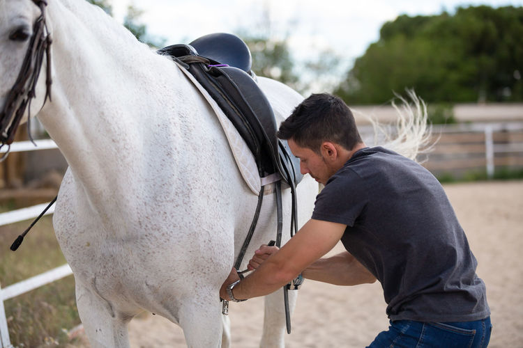 Rear view of man with horse in ranch