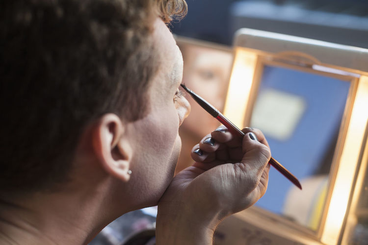 Man applying drag cosmetics