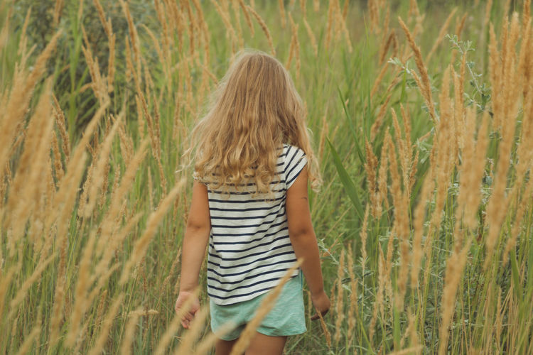 Girl walking on a tall grass