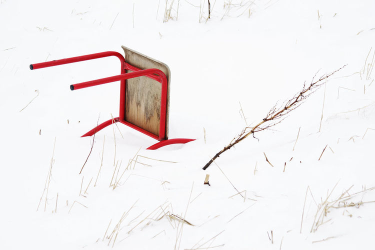 Red chair fallen on snowy field
