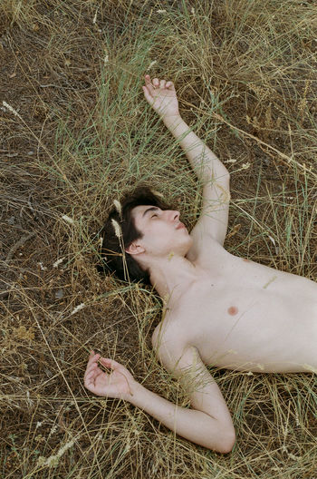 Young boy lying on field