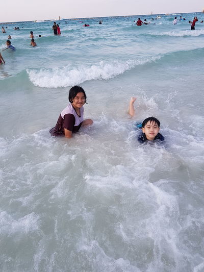 Portrait of siblings enjoying in sea