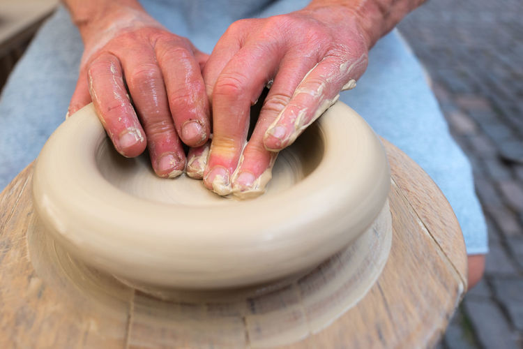 High angle view of hands working pottery