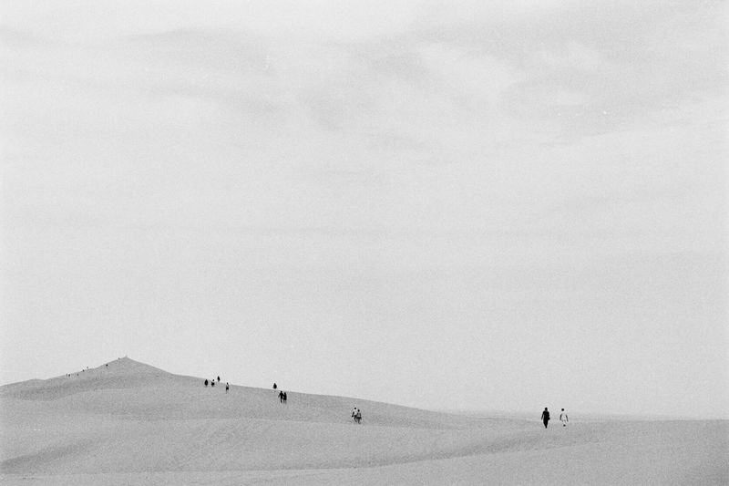 People in desert against sky
