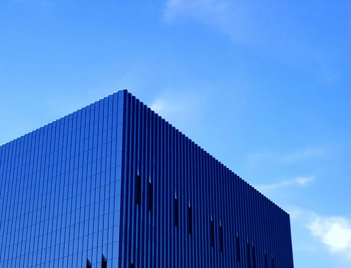 Low angle view of office building against blue sky