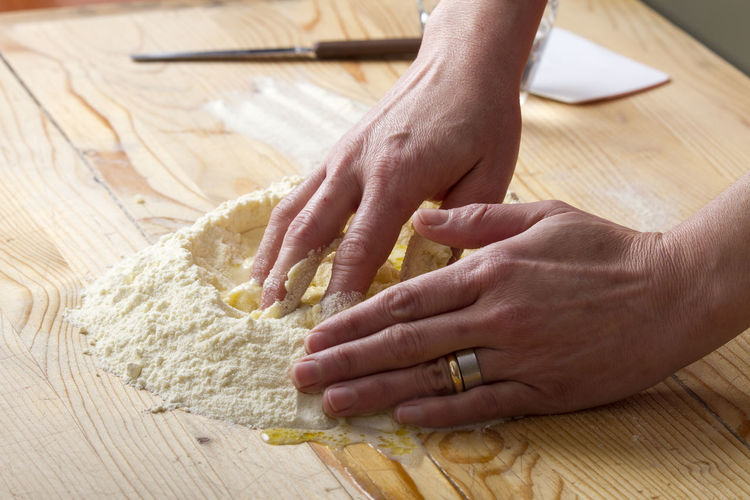 Cropped image of woman hand preparing ravioli dough on table