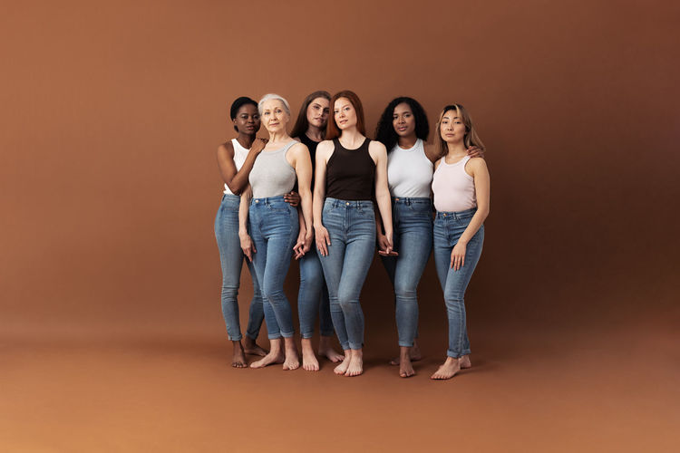 High angle view of friends standing against colored background