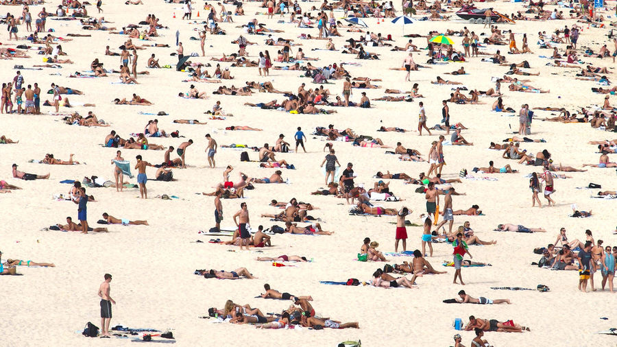 People relaxing on sand at beach