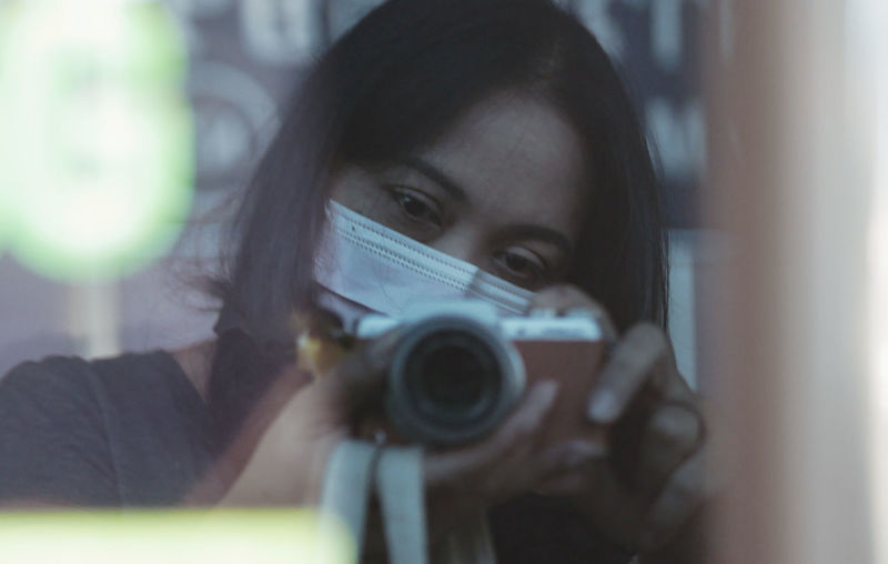 Portrait of woman wearing mask photographing outdoors