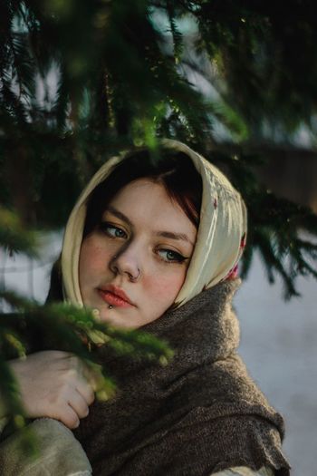 Close-up of woman wearing headscarf and shawl looking away by tree
