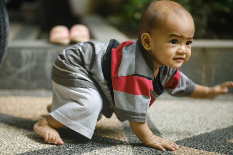 Portrait of cute boy crawling outdoors