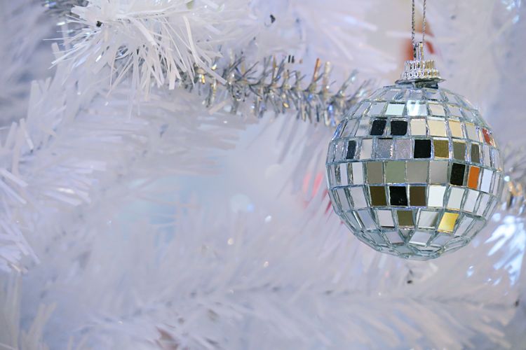 Close-up of christmas decoration hanging against tinsels