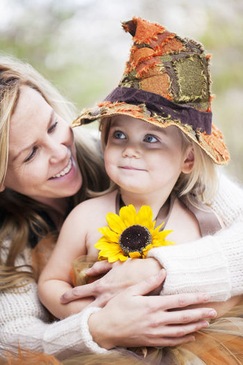 Smiling girl wearing witch hat with mother