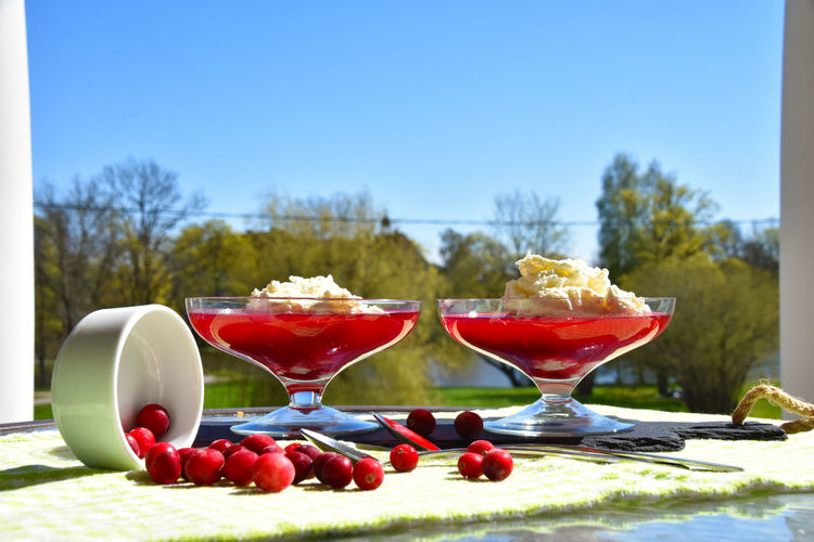 Close-up of drink on table against blue sky