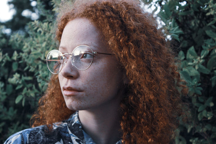 PORTRAIT OF A YOUNG WOMAN LOOKING AWAY OUTDOORS