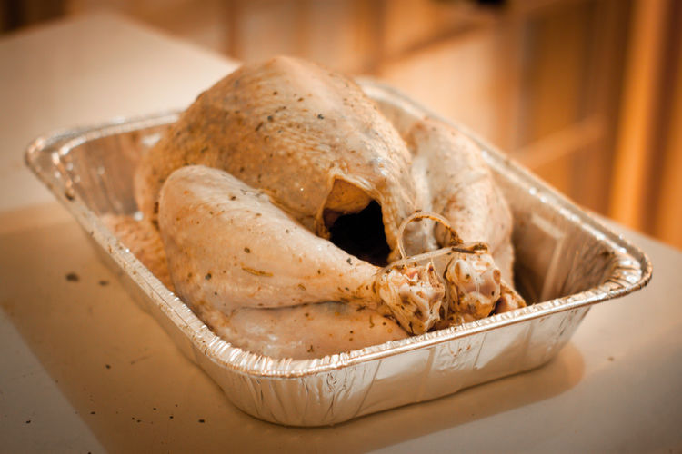 Close-up of marinated turkey in baking tray on table