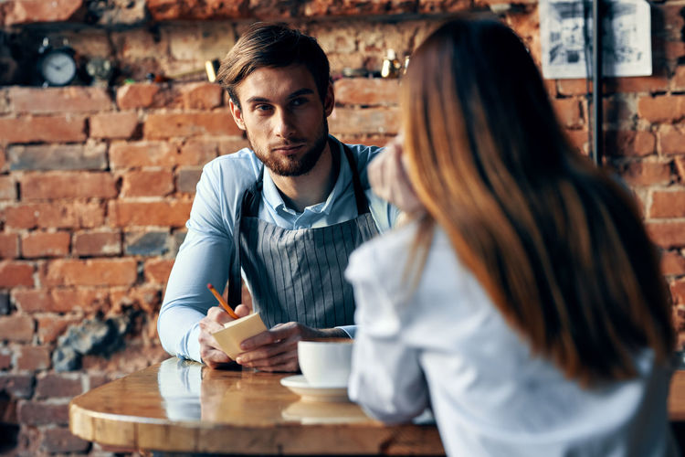 Young couple sitting on table at cafe