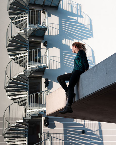 SIDE VIEW OF WOMAN ON STAIRCASE IN CITY
