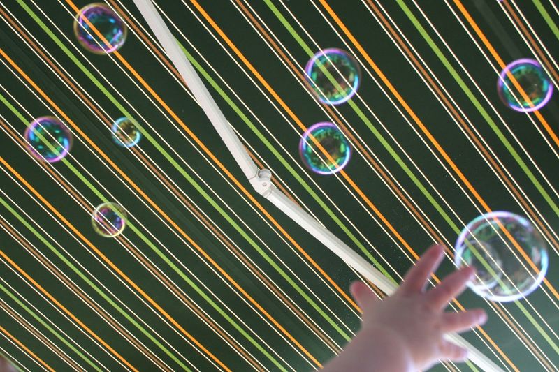 Cropped image of hand catching bubbles