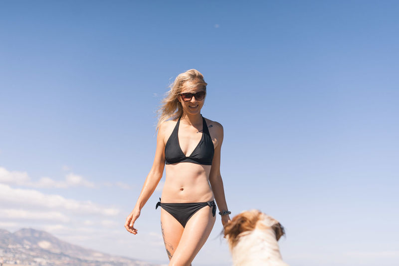 Young woman in bikini against sky