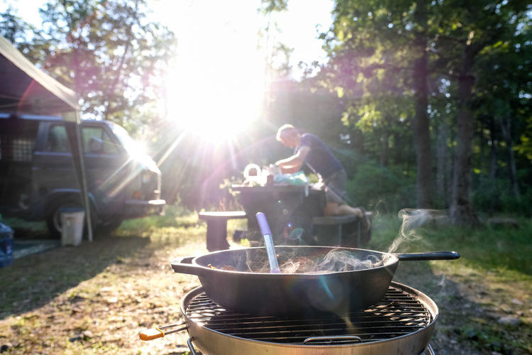 Man setting up dinner at campground food on stove