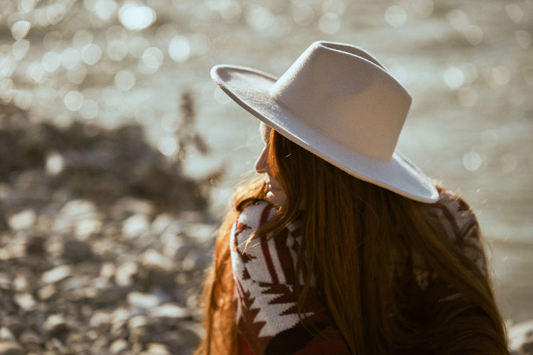 Rear view of woman wearing hat standing outdoors