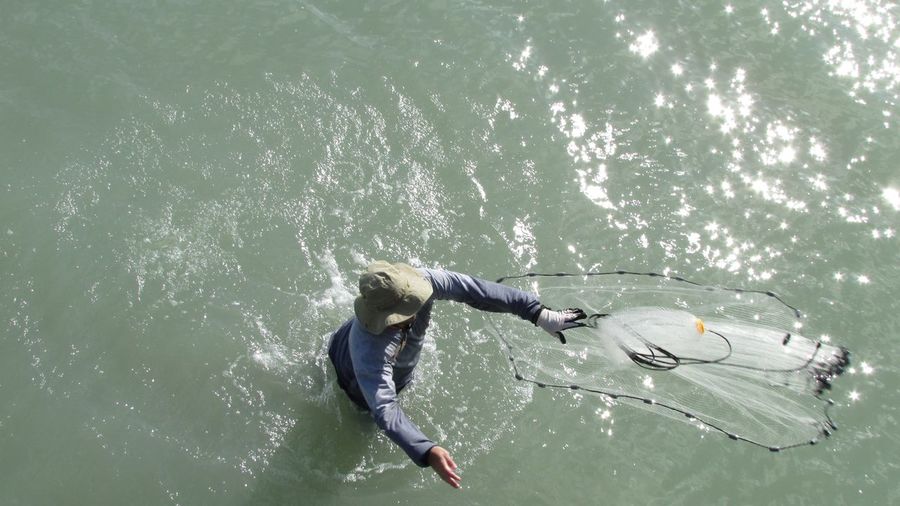 High angle view of man fishing with net