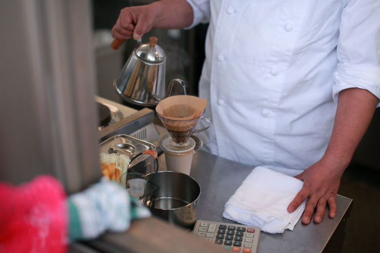 Midsection of man preparing food in cafe