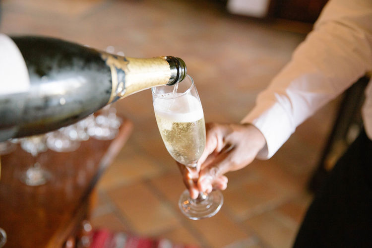 Cropped image of hand pouring champagne in glass
