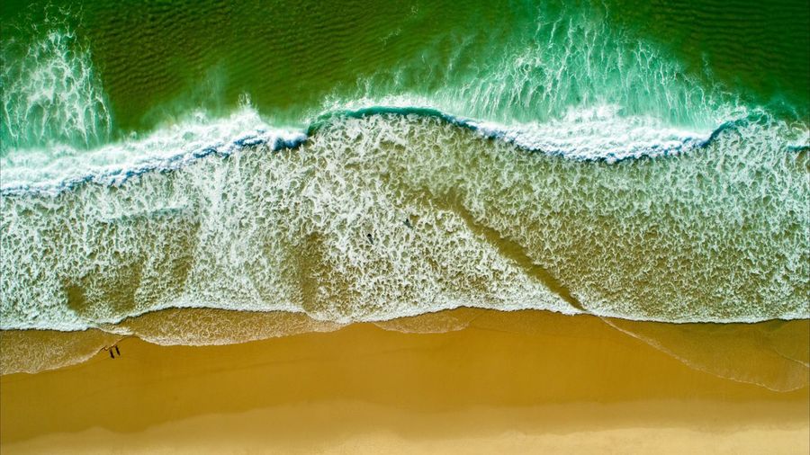 Aerial view of sea waves on beach
