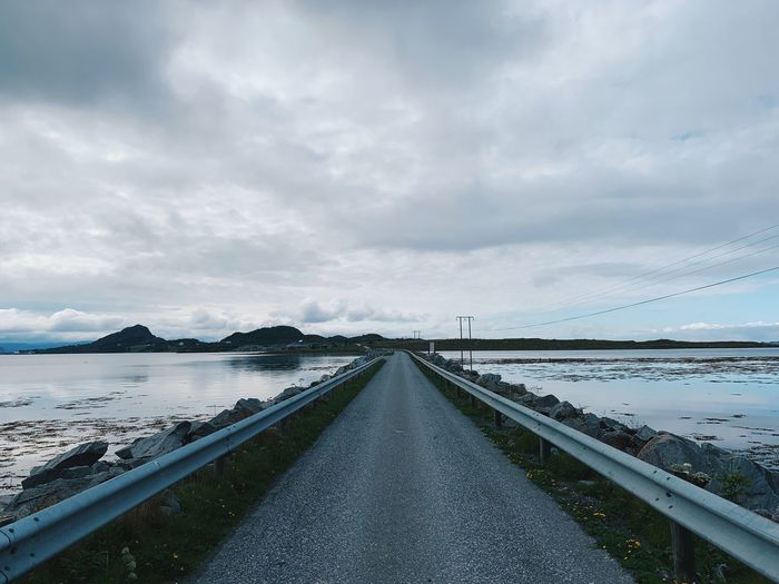 Empty and endless road in the middle of a nordic landscape, seashore, horizon over land and islands 