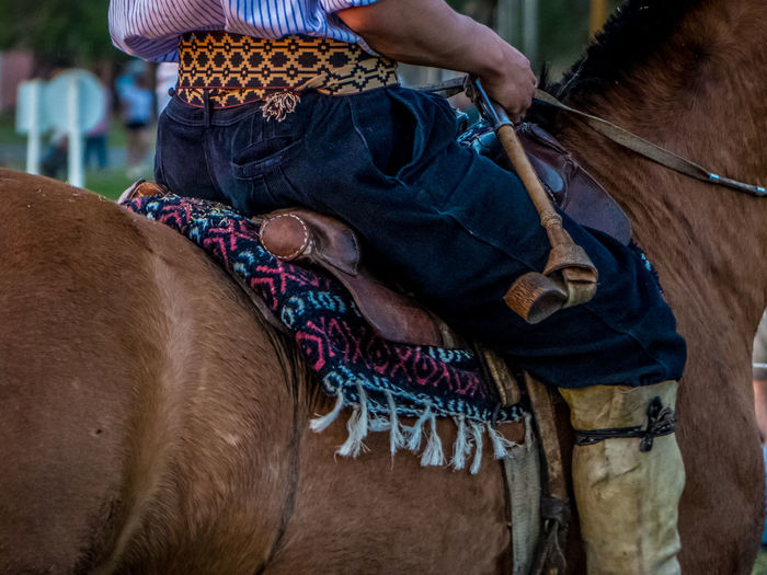 Midsection of man riding horse