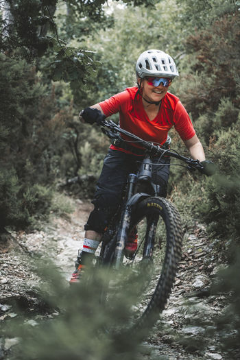 Portrait action shot of young female mountainbiker on trail