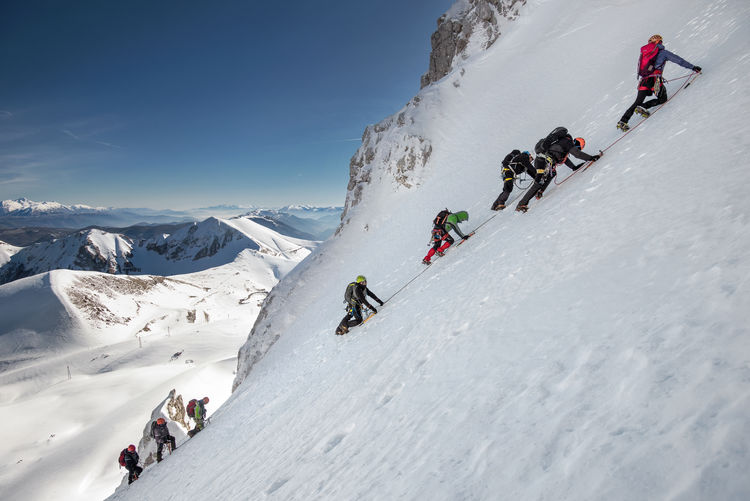 People climbing on snowcapped mountains during winter