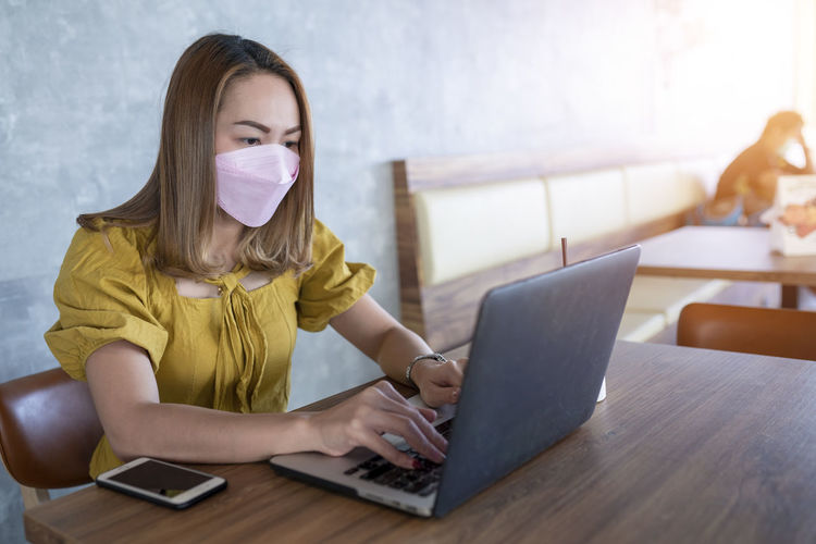 Young woman using laptop at table