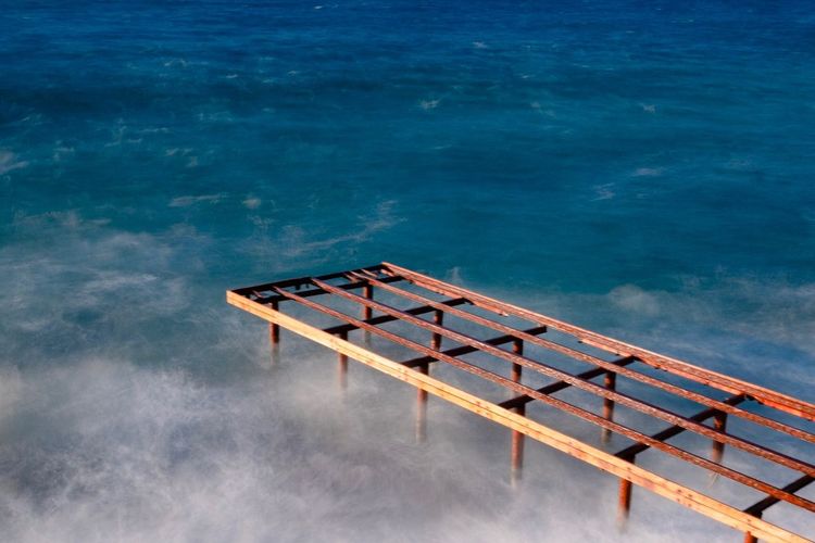 High angle view of ladder by swimming pool against sea