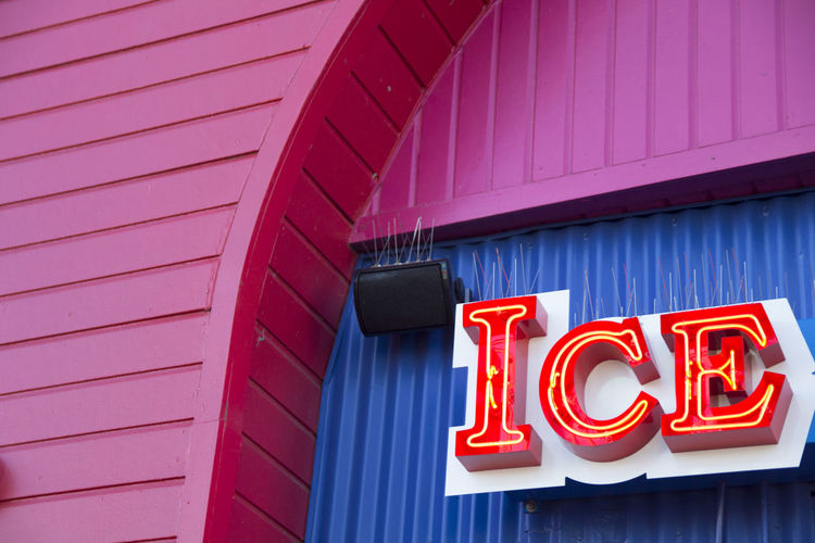 Low angle view of illuminated ice cream sign on wall