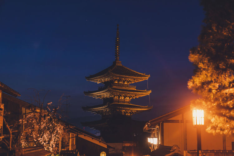 Low angle view of illuminated buildings against sky at night