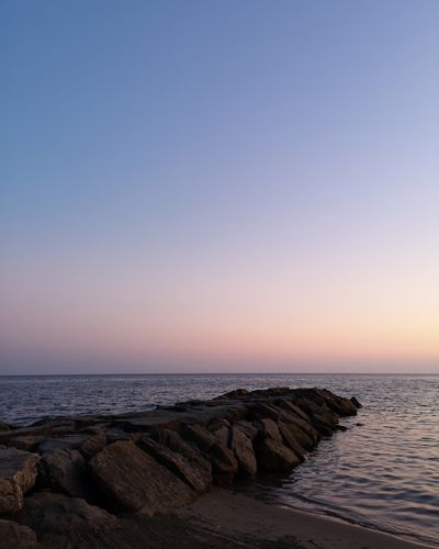 Scenic view of sea against clear sky during sunset