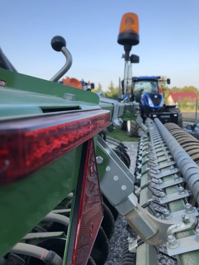 Close-up of machinery on field against sky