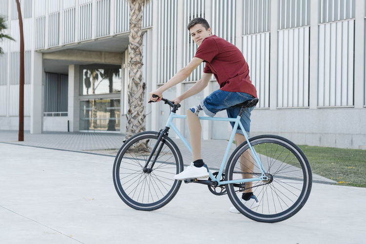 Young disabled cyclist riding bike in city